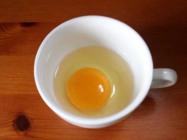 Сырое яйцо в чашке.