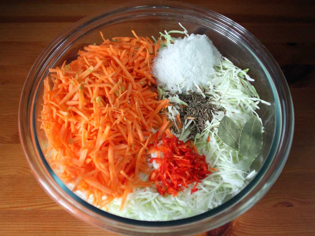 Капуста, морковь, красный острый перец, соль, тмин и лавровый лист.
