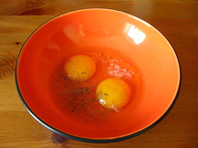 Яйця в мисці посолені і поперчені.