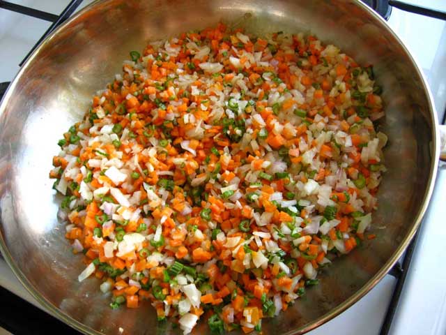 Дрібно порізані цибуля, часник, селера і морква обсмажуються на сковорідці.