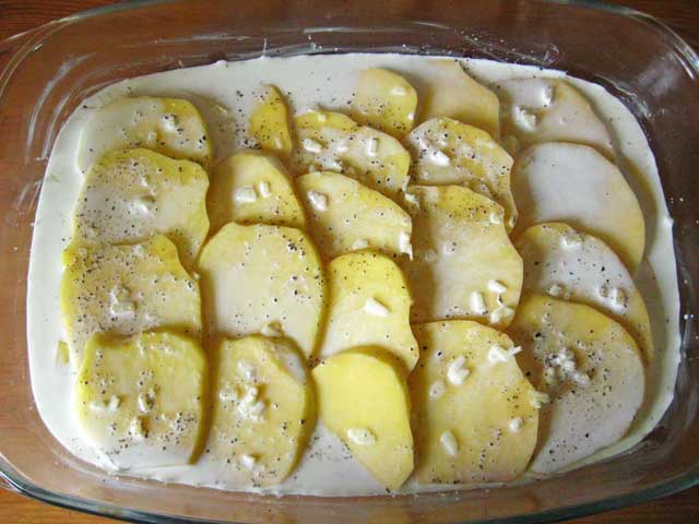 Картофель приправленный солью с перцем и залить сливками.