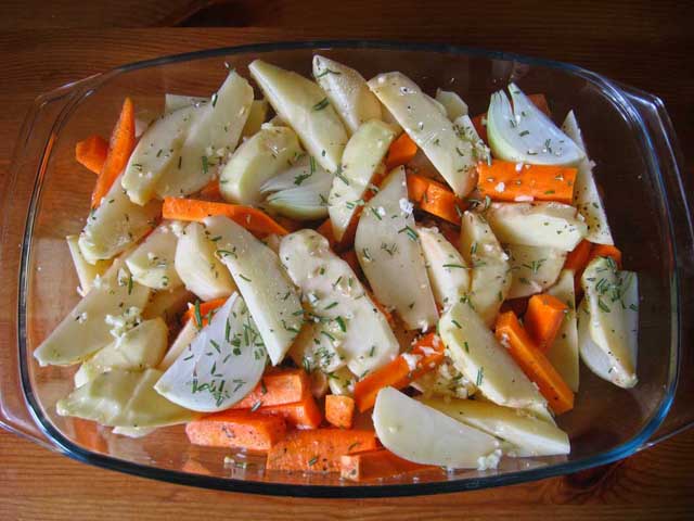 Картофель, морковь и лук перемешанные с розмарином и чесноком.