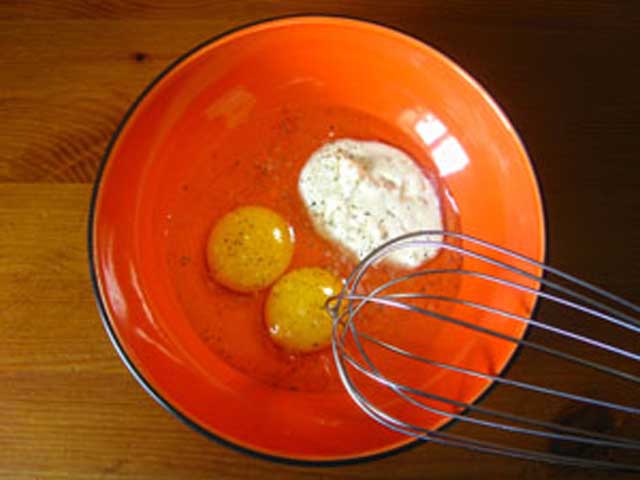 Яйця і сметана в посудині. Солимо і перчимо.