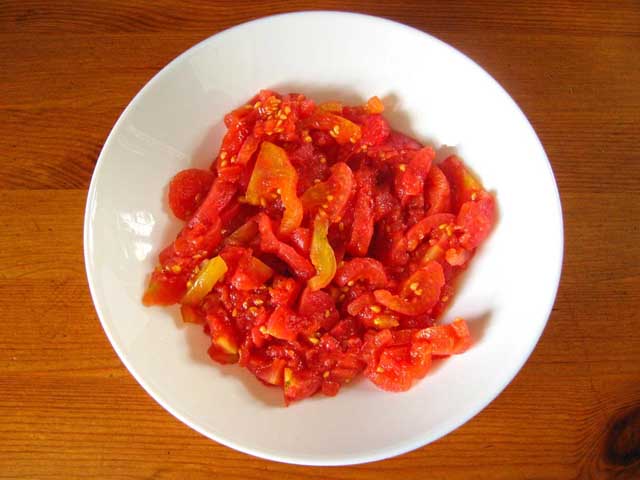 Нарізані півкільцями помідори.