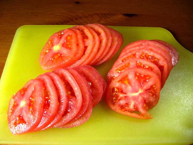 Порізані кружальцями помідори.