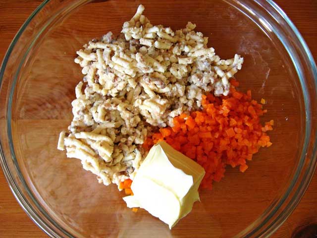 Філе оселедця, плавлені сирки, морква і вершкове масло в посудині.