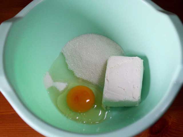 Яйцо, сахар и творог в миске.