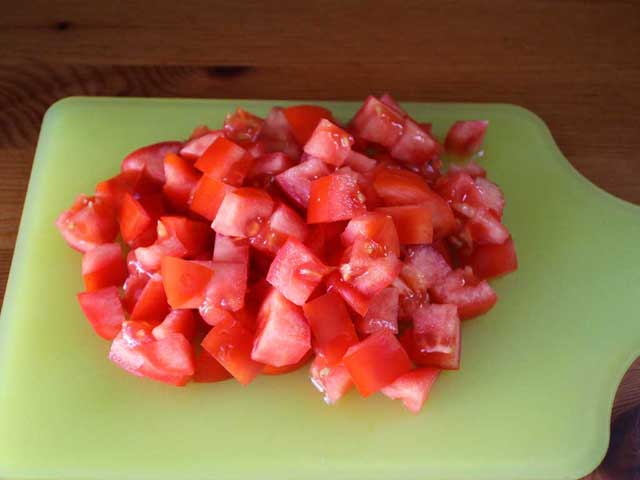 Порізані кубиками помідори.