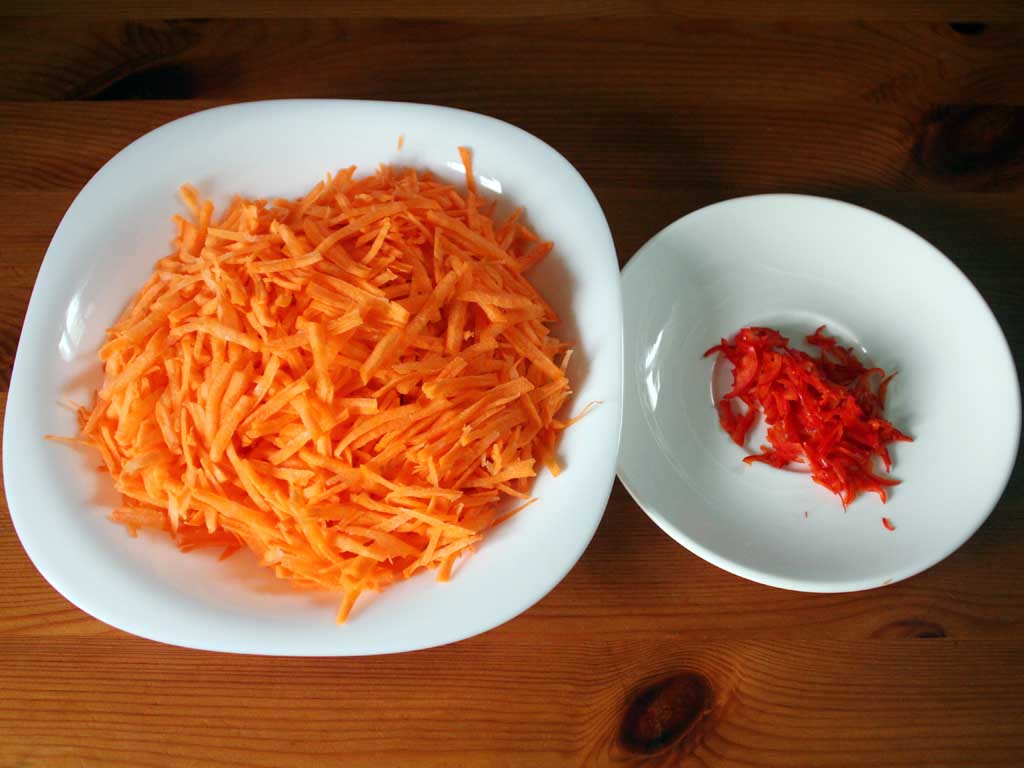 Натертая морковь и мелко порезанный красный острый перец.
