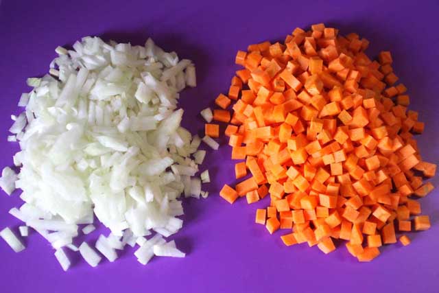 Порізані кубиками цибуля та морква.