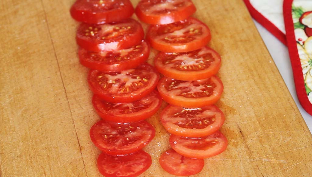 Нарізані кільцями помідори.