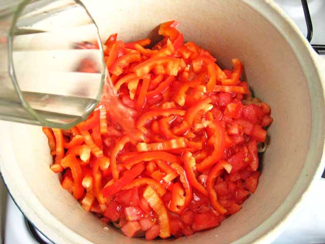 Додаємо в сотейник помідори, перець і воду.