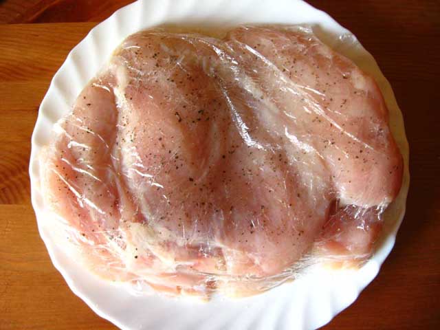 Приправленное солью и перцем филе, покрытое пищевой пленкой.