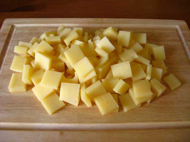 Нарезанный кубиками сыр.