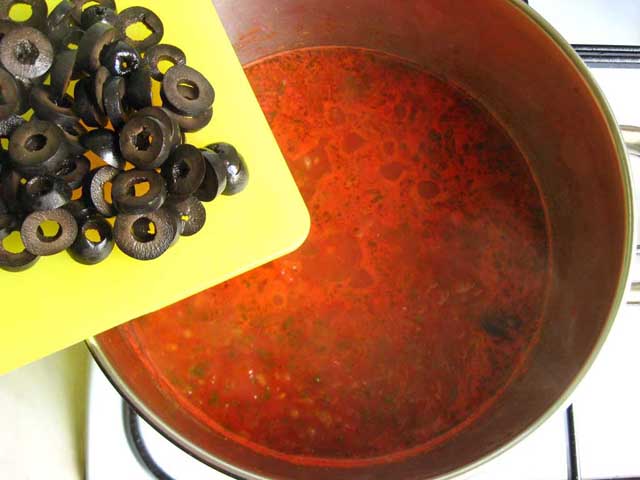 В кастрюлю с томатным соусом добавляем оливки.
