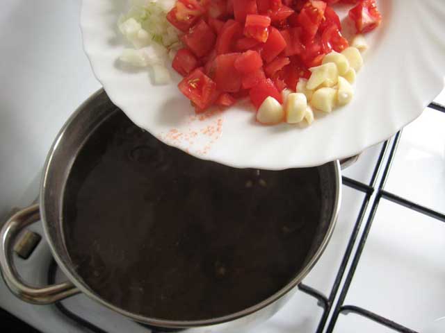 Додаємо цибулю, помідори, часник, сіль, перець, лавровий лист і кумін.