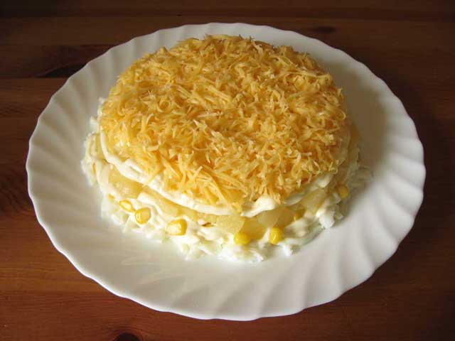 Выложенный тертый сыр на ананасе