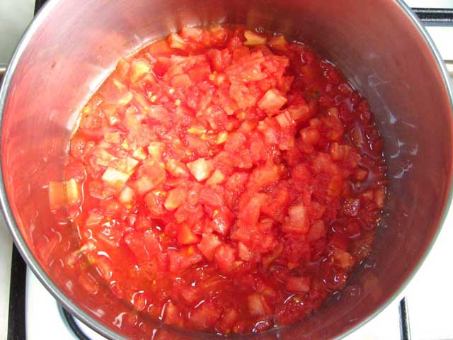 Нарізані кубиками помідори в каструлі.